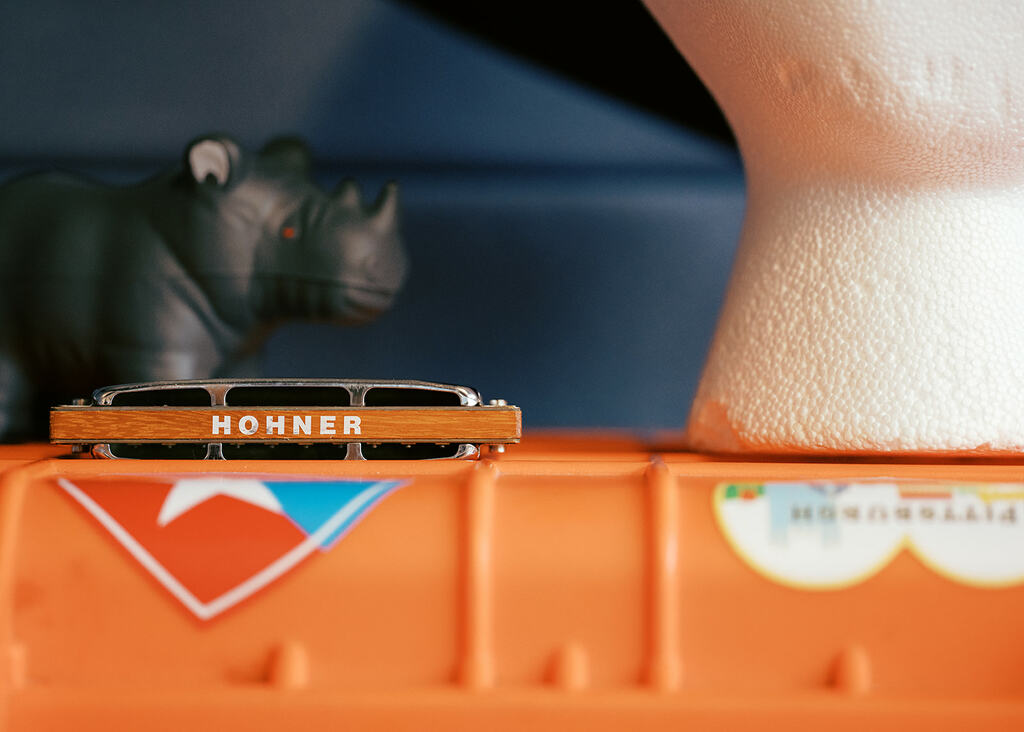 Image of the top of an orange box with a harmonica, rhino, and Styrofoam head sitting on top